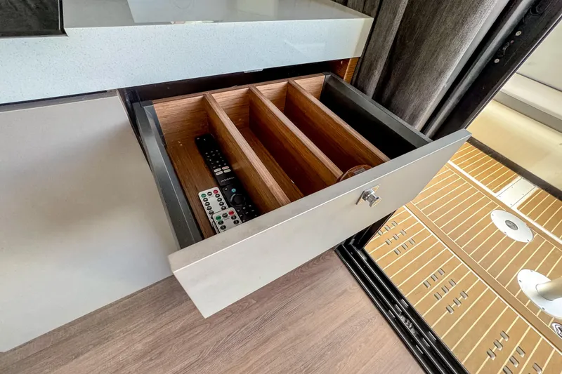 Slide: The Image of Open drawer with remote controls in 2024 Beneteau America Antares 11 boat interior. - 21