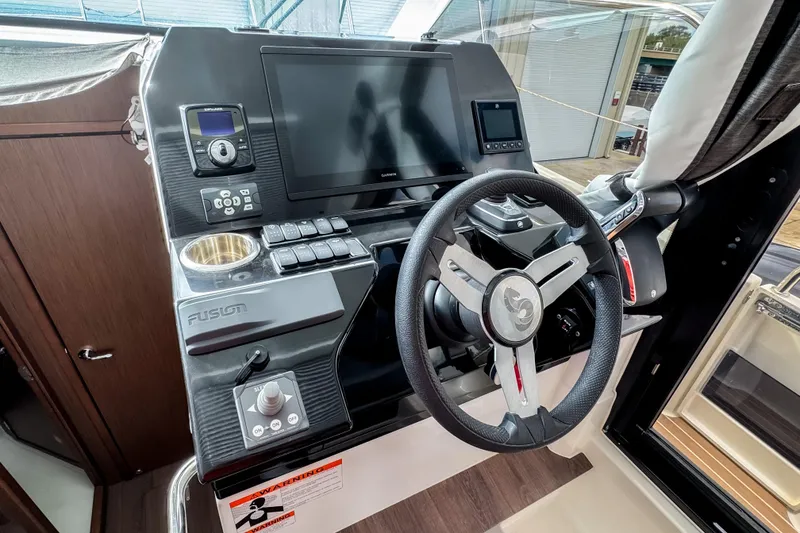 Slide: The Image of 2024 Beneteau Antares 11 helm with steering wheel, touchscreen, and control panel. - 24