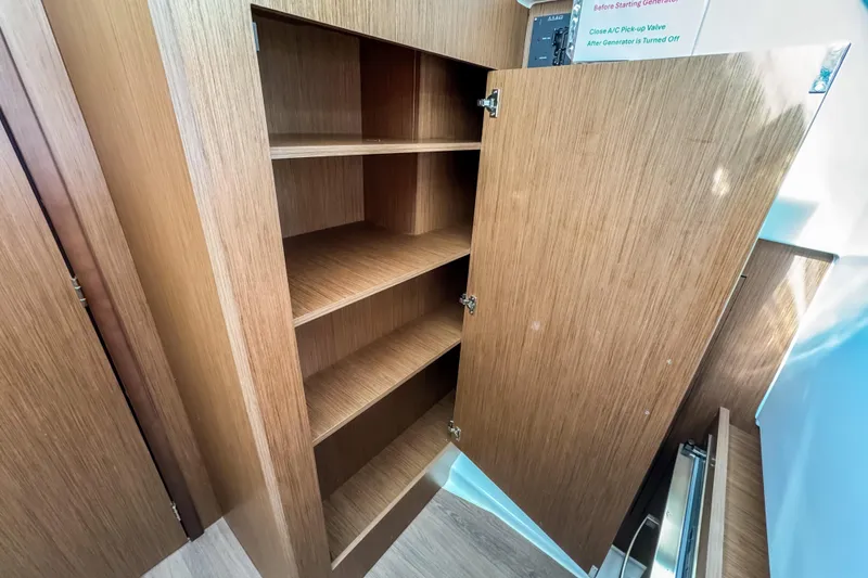 Slide: The Image of 2024 Beneteau Antares 11 interior wooden cabinet with open shelves. - 27