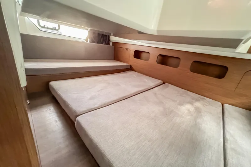 Slide: The Image of 2024 Beneteau Antares 11 cabin interior with cozy bedding and wooden accents. - 29