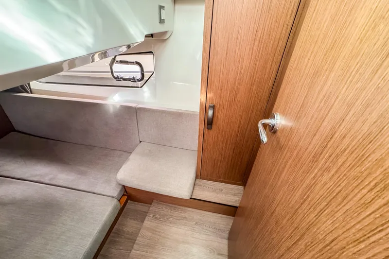 Slide: The Image of 2024 Beneteau Antares 11 cabin interior with wood finish and seating area. - 30