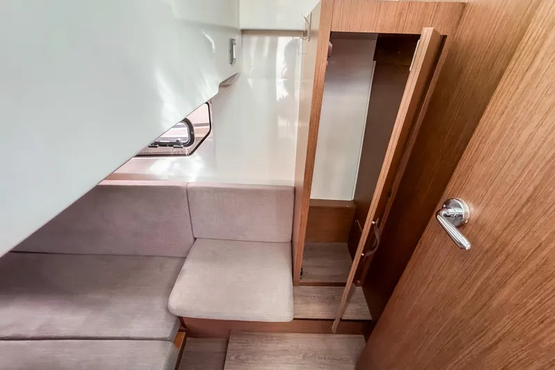 Slide: The Image of 2024 Beneteau Antares 11 cabin interior with wooden finish and seating area. - 31