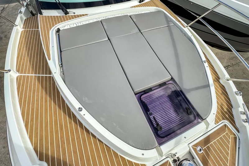 Slide: The Image of 2024 Beneteau Antares 11 boat deck with cushioned seating and wood finish. - 39