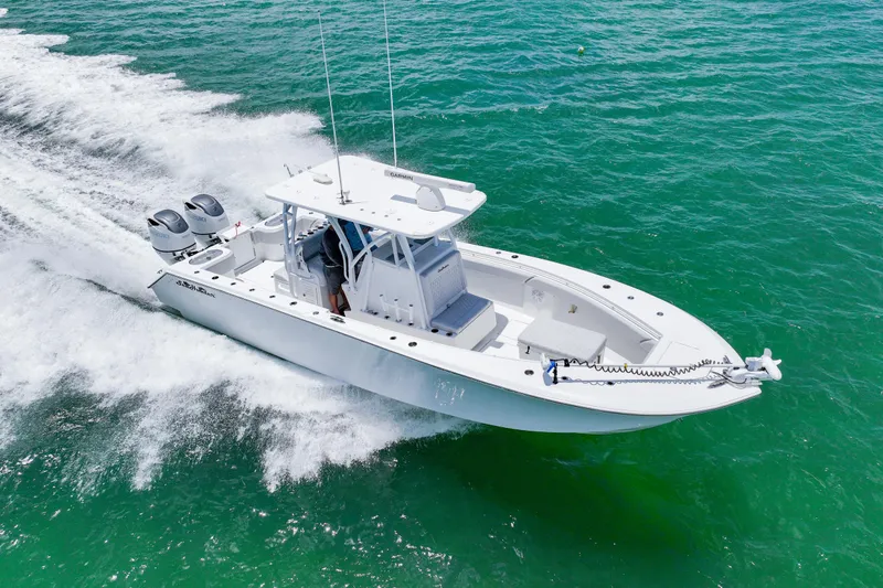 Slide: The Image of 2023 SeaHunter 31 Tournament boat cruising on clear turquoise waters. - 4