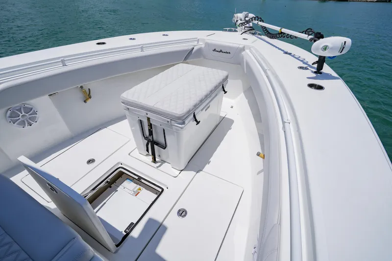 Slide: The Image of 2023 SeaHunter 31 Tournament boat deck with storage and seating, on calm water. - 8