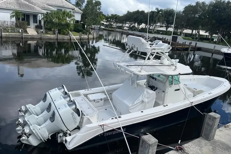 Slide: The Image of 2008 Everglades 350 Center Console boat docked in a serene waterfront setting. - 2