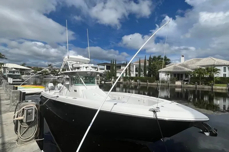 Slide: The Image of 2008 Everglades 350 Center Console boat docked by waterfront homes under a cloudy sky. - 3