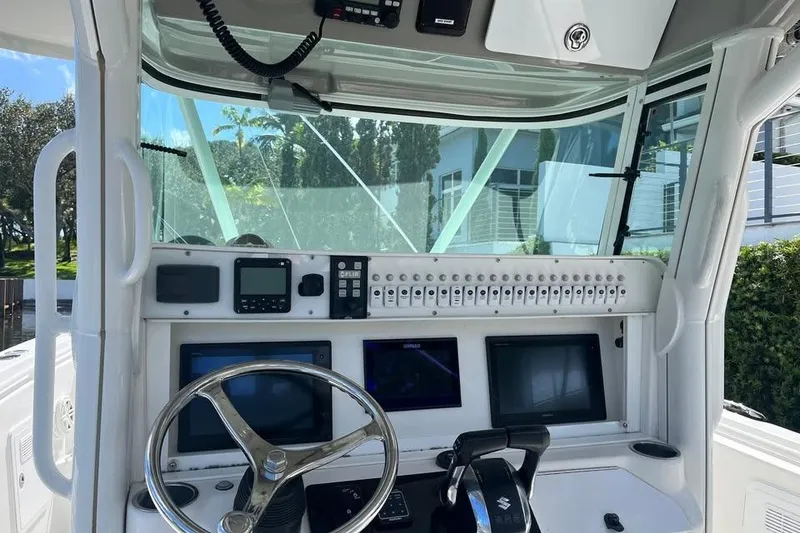 Slide: The Image of 2008 Everglades 350 Center Console boat dashboard with steering wheel and electronic controls. - 4