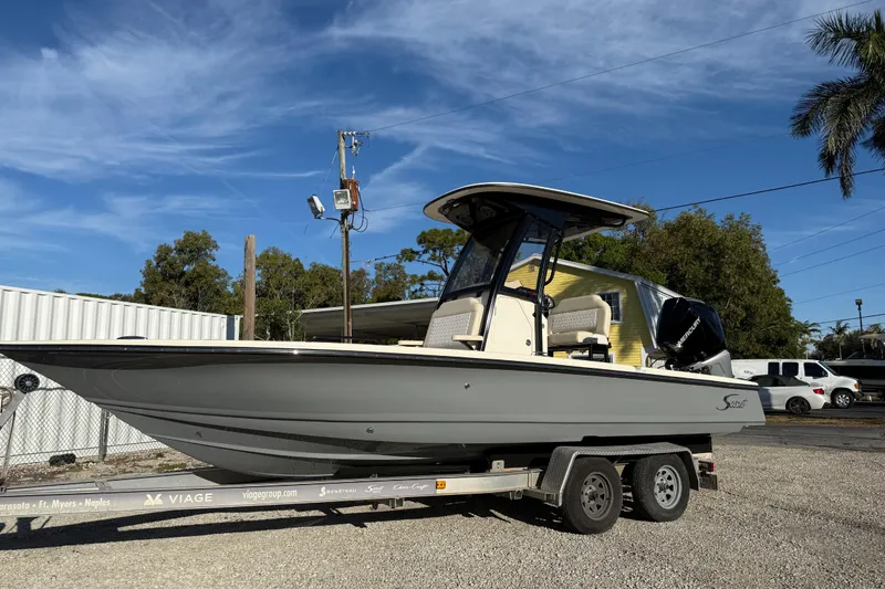 The Image of 2026 Scout 231 XSB boat on trailer, parked outdoors under clear blue sky. - 1