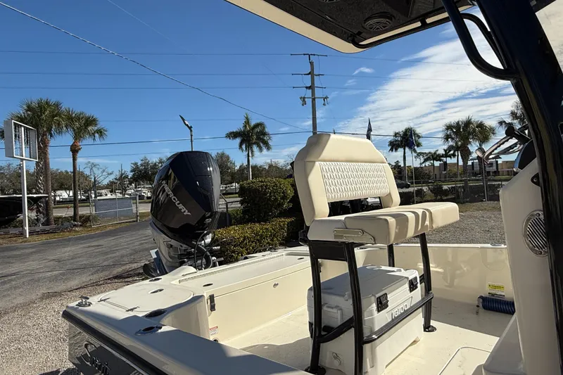 Slide: The Image of 2026 Scout 231 XSB boat with Mercury engine, parked outdoors under clear blue sky. - 5