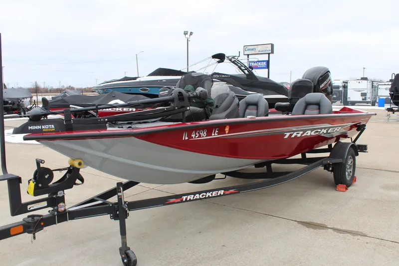 Slide: The Image of 2023 Tracker Pro Team 175 TXW boat on trailer, red and gray, parked outdoors. - 3