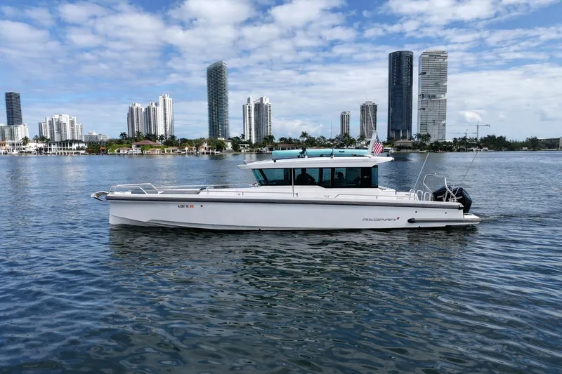 The Image of 2022 Axopar 37 XC Cross Cabin boat cruising near city skyline. - 0