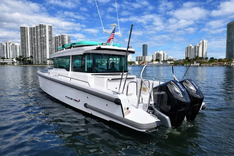 Slide: The Image of 2022 Axopar 37 XC Cross Cabin boat on water with city skyline background. - 3