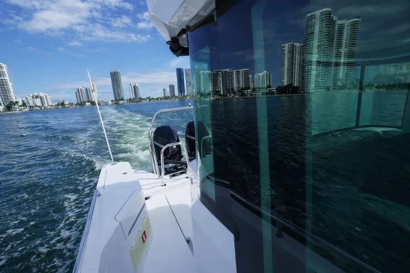 Slide: The Image of 2022 Axopar 37 XC Cross Cabin cruising near city skyline on a sunny day. - 4