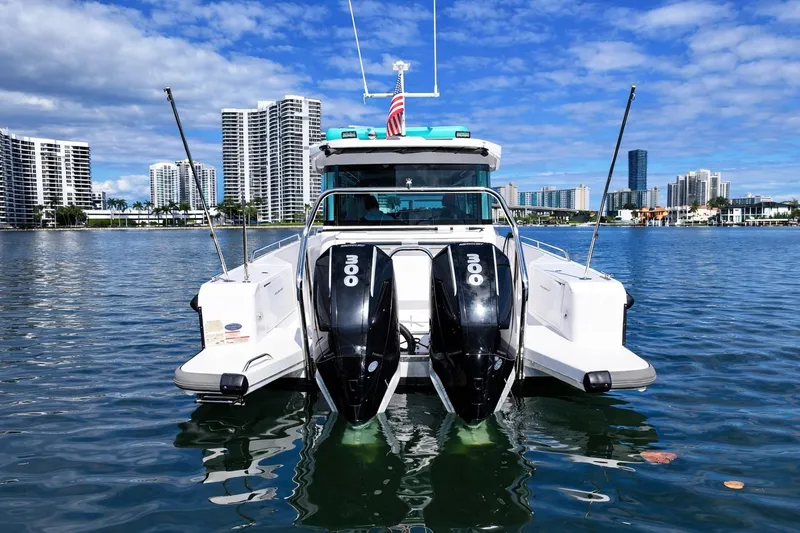 Slide: The Image of 2022 Axopar 37 XC Cross Cabin boat with dual engines on a sunny waterfront. - 7