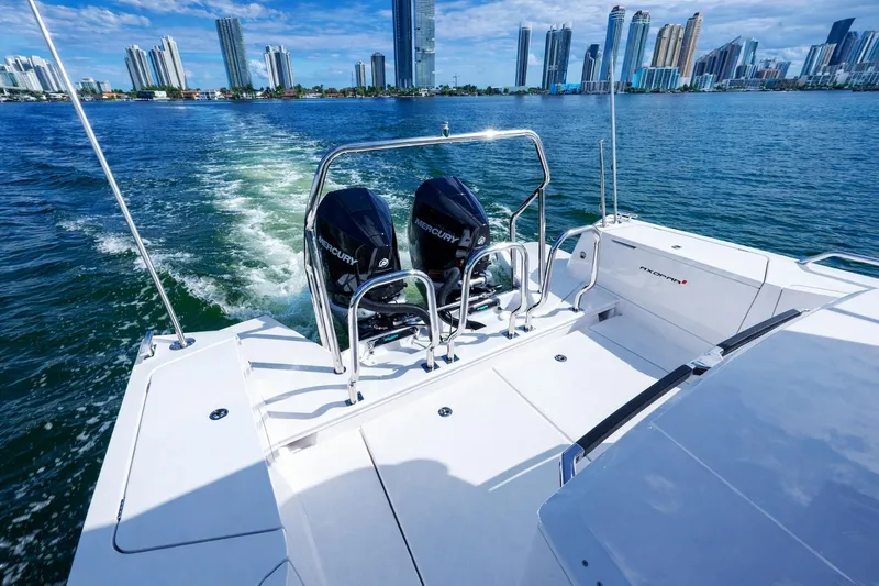 Slide: The Image of 2022 Axopar 37 XC Cross Cabin cruising near city skyline, featuring dual Mercury engines. - 8