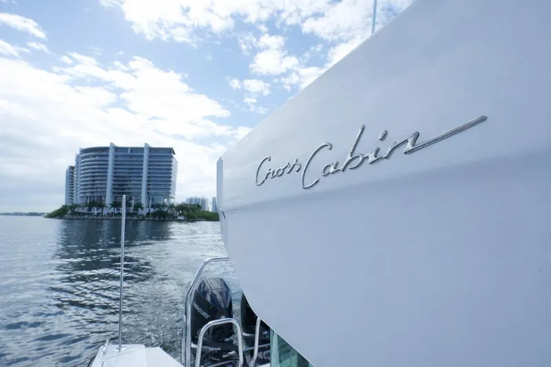 Slide: The Image of 2022 Axopar 37 XC Cross Cabin boat near waterfront buildings under cloudy sky. - 9