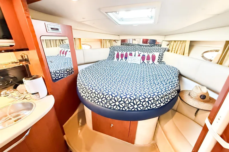 Slide: The Image of 2004 Chaparral Signature 350 cabin with cozy bed, patterned bedding, and nautical decor. - 17