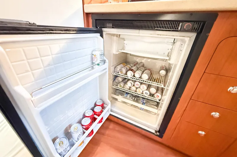 Slide: The Image of Mini fridge stocked with beverages inside a 2004 Chaparral Signature 350 boat cabin. - 27