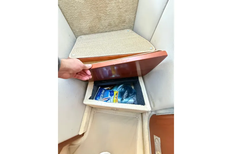 Slide: The Image of Hand opening storage compartment on 2004 Chaparral Signature 350 boat interior. - 28