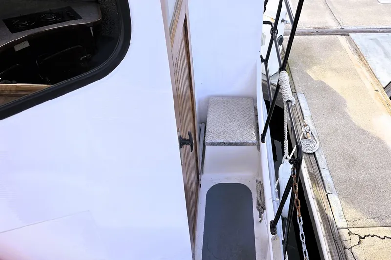 Slide: The Image of 2016 Custom 25 Tug boat docked, showing deck and entryway details. - 12