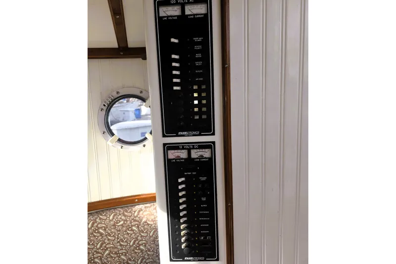 Slide: The Image of Electrical panel on a 2016 Custom 25 Tug boat interior, featuring AC and DC controls. - 22