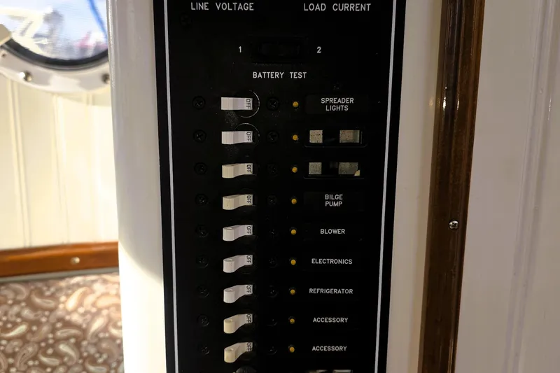 Slide: The Image of Electrical panel on a 2016 Custom 25 Tug boat, featuring switches and battery test indicators. - 24