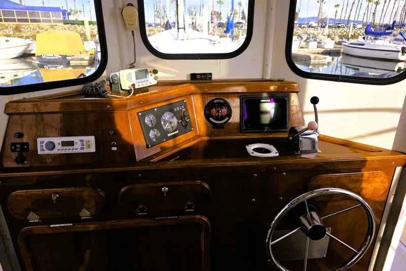 Slide: The Image of Interior of a 2016 Custom 25 Tug boat with wooden dashboard and navigation instruments. - 28