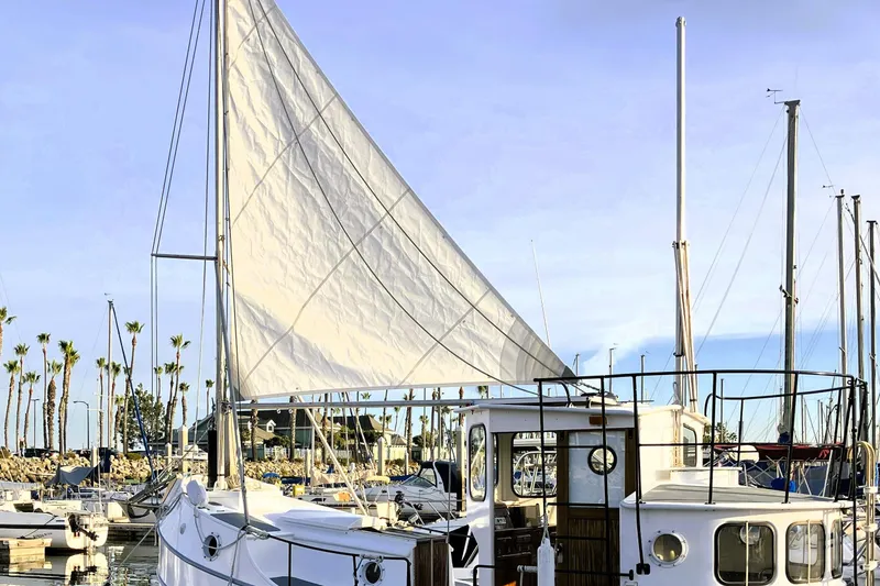 Slide: The Image of Custom 2016 model 25 Tug sailboat docked in a marina with palm trees. - 64