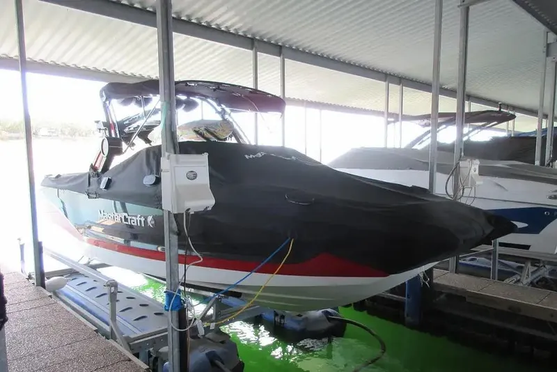 Slide: The Image of 2022 MasterCraft X24 boat covered and docked in a sheltered marina. - 4