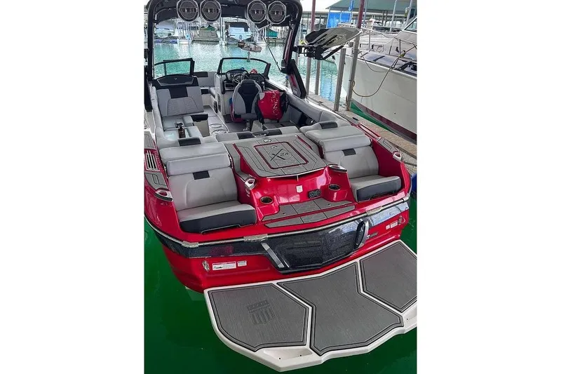 Slide: The Image of 2022 MasterCraft X24 boat with red and gray interior, docked at marina. - 5
