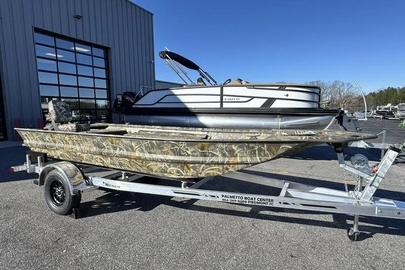 The Image of 2026 War Eagle 648LDV boat on trailer, camouflage design, parked outside a building. - 1