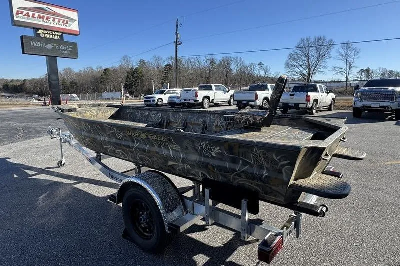 Slide: The Image of 2026 War Eagle 648LDV boat on trailer at dealership parking lot. - 12
