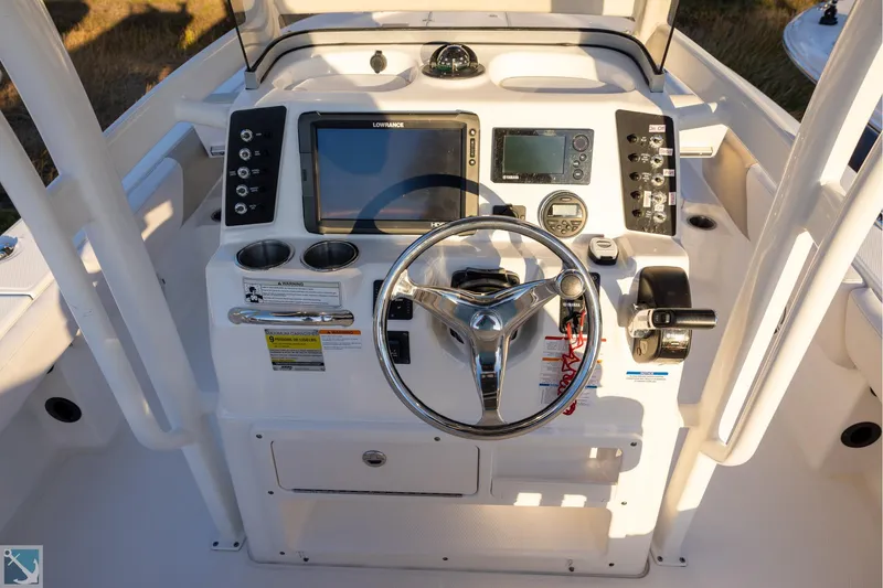 Slide: The Image of 2016 Robalo 246 Cayman boat dashboard with steering wheel and navigation controls. - 10