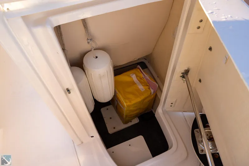 Slide: The Image of Storage compartment of 2016 Robalo 246 Cayman boat with fenders and yellow bag. - 14