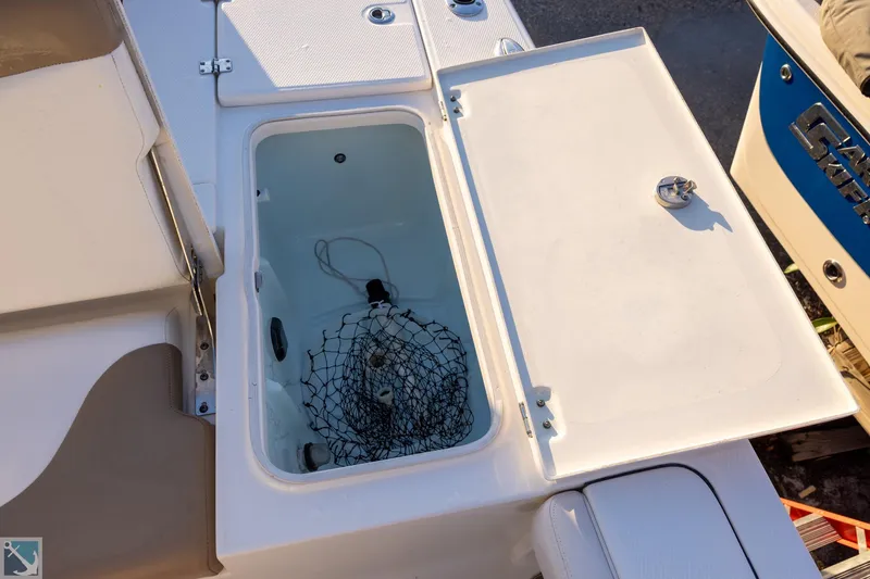 Slide: The Image of Open storage compartment on 2016 Robalo 246 Cayman boat with net inside. - 8