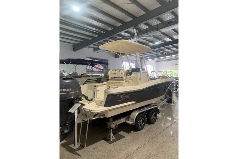 Slide: The Image of 2022 Scout 215 XSF boat displayed indoors on a trailer. - 2