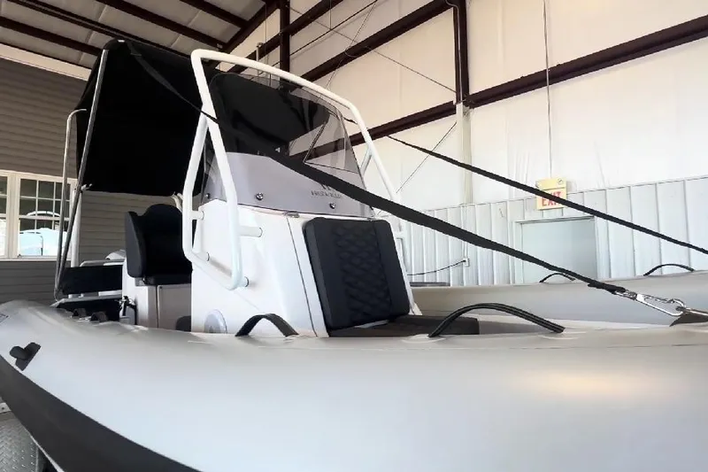 Slide: The Image of 2024 Highfield Sport 660 boat in a warehouse, showcasing sleek design and modern features. - 2