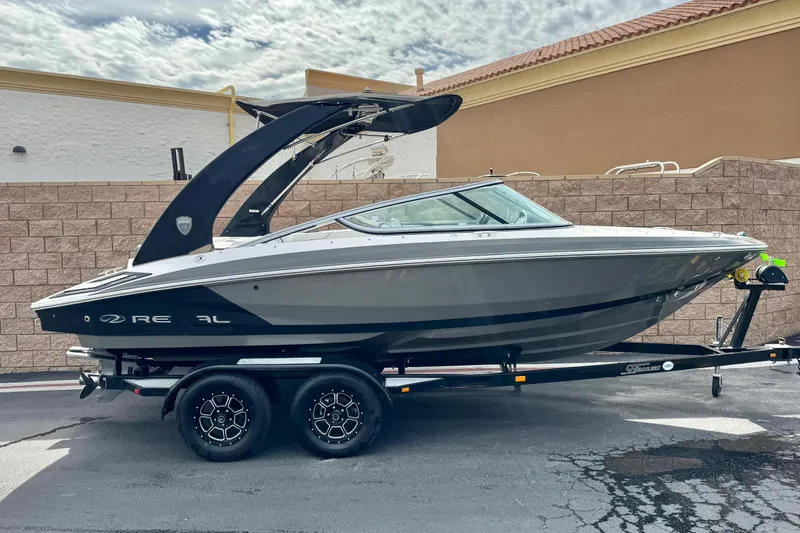 The Image of 2018 Regal 2100 Bowrider boat on trailer, parked outdoors, side view. - 0