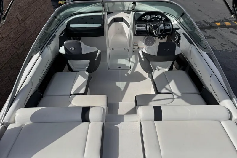 Slide: The Image of 2018 Regal 2100 Bowrider interior with white seating and modern dashboard design. - 10