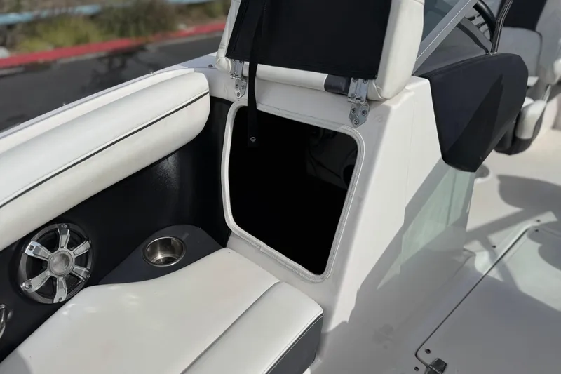 Slide: The Image of 2018 Regal 2100 Bowrider interior with open storage compartment and speaker. - 16