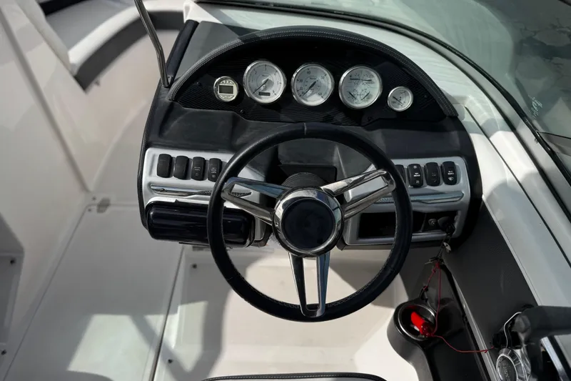 Slide: The Image of Steering wheel and dashboard of 2018 Regal 2100 Bowrider boat, featuring gauges and controls. - 25