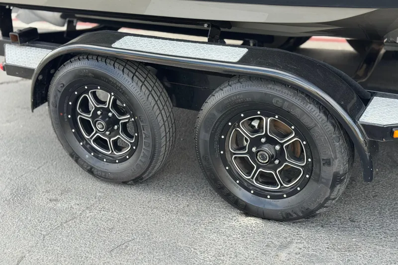 Slide: The Image of Trailer wheels of a 2018 Regal 2100 Bowrider boat on pavement. - 27