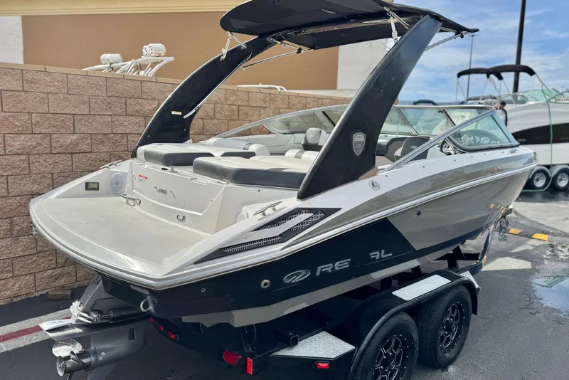 Slide: The Image of 2018 Regal 2100 Bowrider boat on trailer, sleek design, black and white exterior. - 5