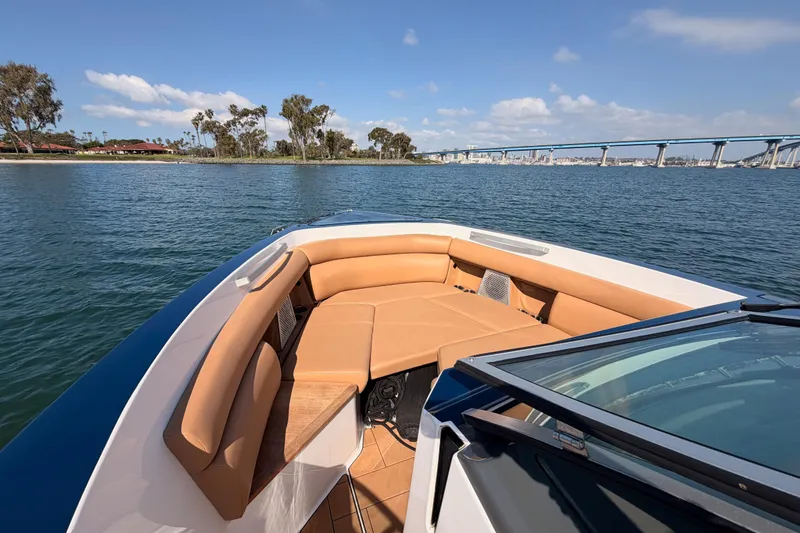 Slide: The Image of 2022 Aviara AV32 I/O boat with tan seating, cruising on a sunny day near a bridge. - 16