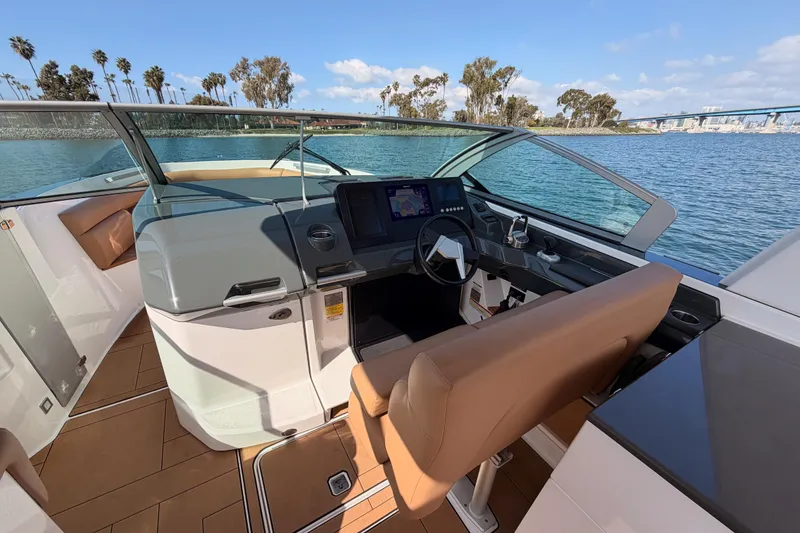 Slide: The Image of 2022 Aviara AV32 I/O boat cockpit with modern controls and scenic water view. - 18