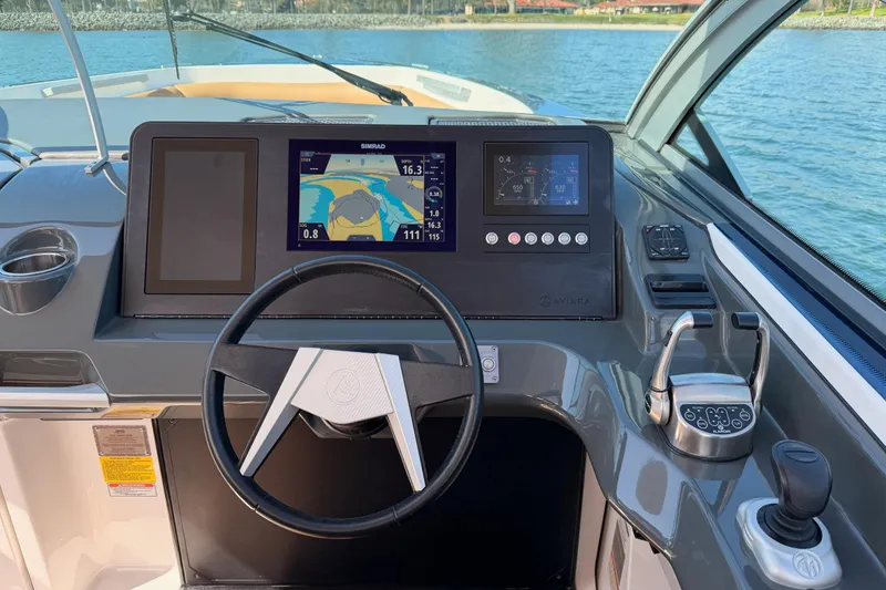 Slide: The Image of 2022 Aviara AV32 I/O boat dashboard with navigation screens and steering wheel. - 21
