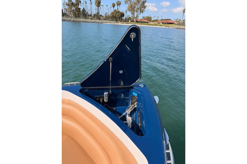 Slide: The Image of 2022 Aviara AV32 I/O boat with open anchor hatch on calm water. - 24