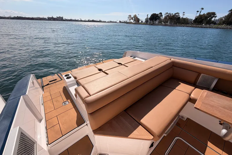 Slide: The Image of 2022 Aviara AV32 I/O boat with tan seating, docked on calm water. - 27