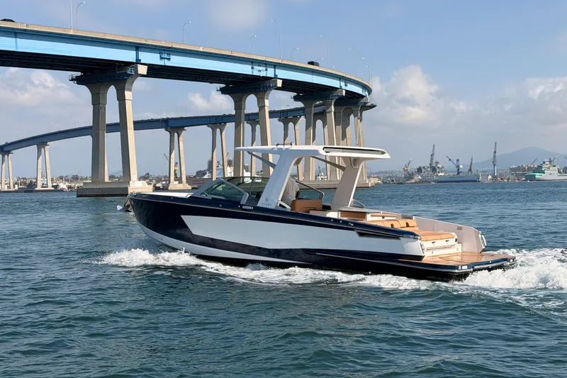 Slide: The Image of 2022 Aviara AV32 I/O boat cruising under a bridge on a sunny day. - 34